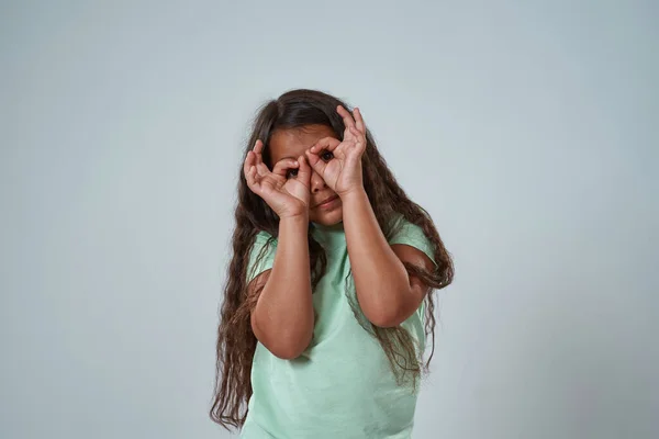 Menina latina olhar para a câmera através do sinal binóculos — Fotografia de Stock