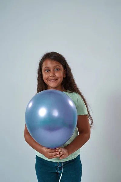 Latina niña sostener globo y mirar a la cámara —  Fotos de Stock