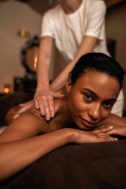 Ovalamada siyah kadına masör tuzu sürdü.