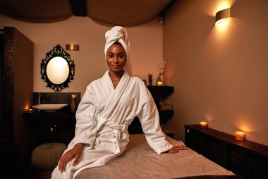 Masaj masasında gülümseyen siyah kız.