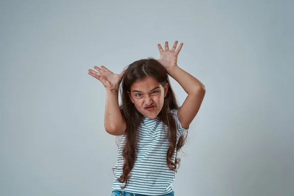 Girl with face expression showing horns gesture — Stock Photo, Image