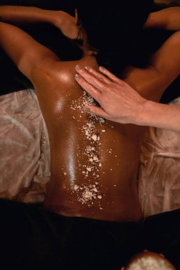 Kadının sırtına tuz süren masör manzarası.