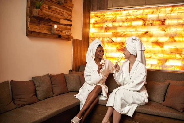 Namoradas alegres bebem champanhe no salão de spa — Fotografia de Stock