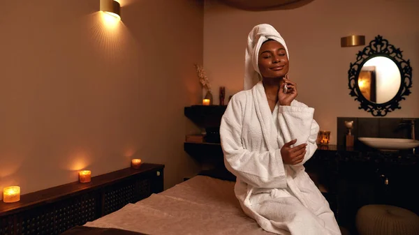 Menina africana agradável tocando-se no salão de spa — Fotografia de Stock