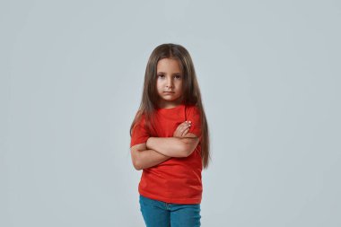 Kollarını kavuşturmuş kendine güvenen bir kız.