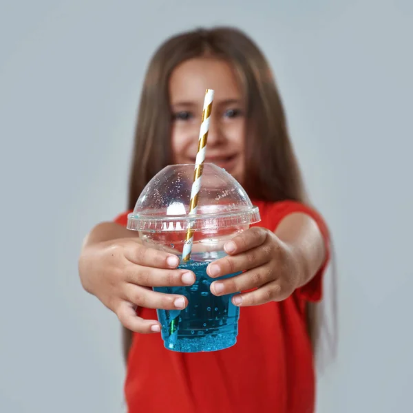 Cup with soda drink in hands of blur little girl — Stock Photo, Image