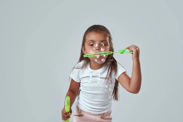 Cropped of little girl blowing soap bubbles in air