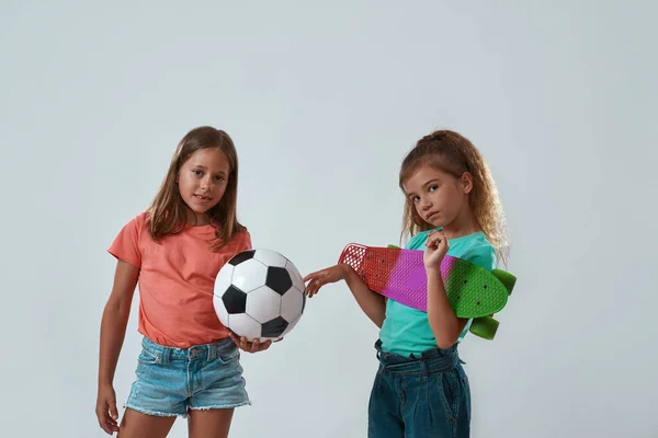 Lányok pózolnak focilabdával és gördeszkával — Stock Fotó