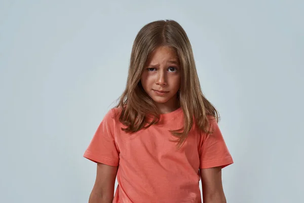 Egy kislány szkeptikus arccal a kamerába néz. — Stock Fotó