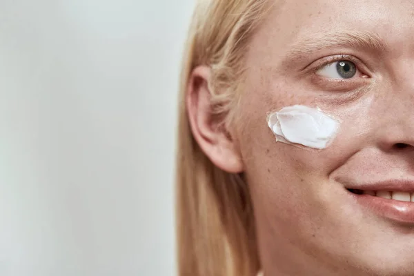 Oscura cara de chico con crema cosmética en la cara —  Fotos de Stock