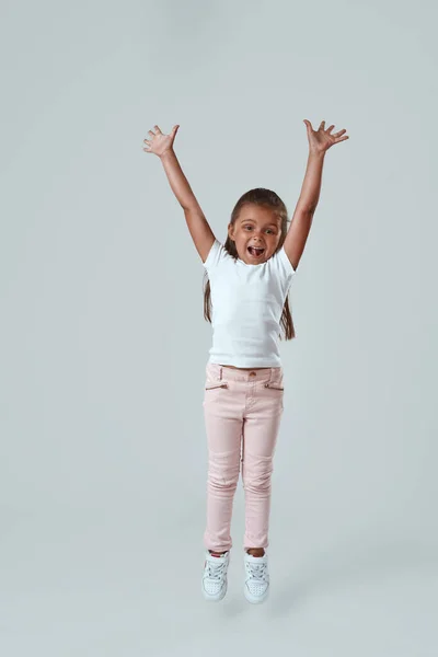 Feliz chica caucásica con las manos en el aire saltando —  Fotos de Stock