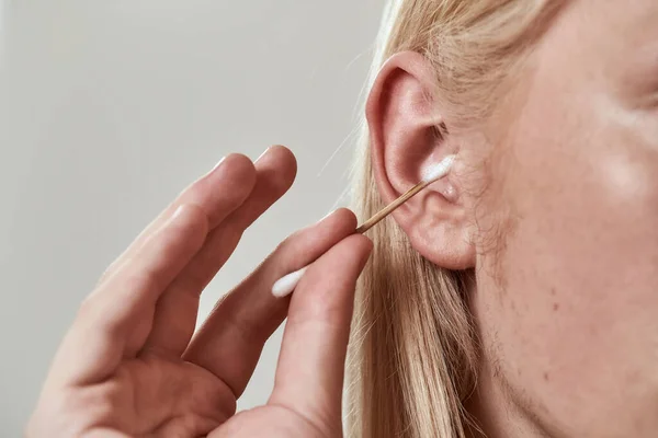 Close-up de cara limpeza orelha direita com auricular — Fotografia de Stock