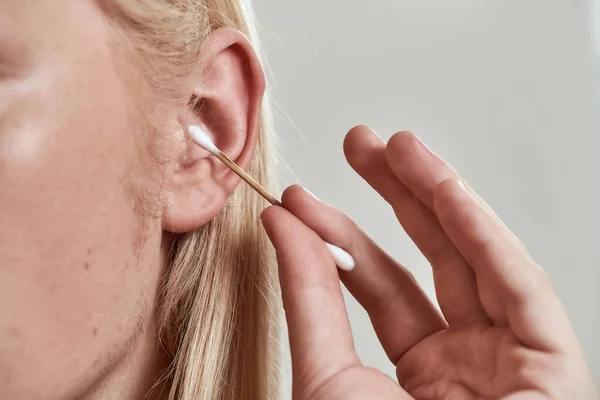 Close-up de cara limpeza orelha esquerda com auricular — Fotografia de Stock