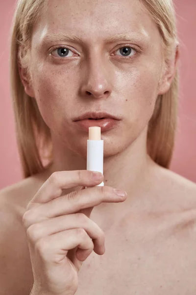 Pria kaukasia mengecat bibir dengan lipstik higienis — Stok Foto