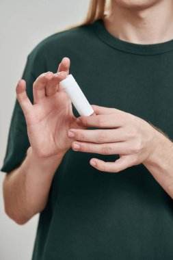 Elinde ilaç şişesi olan bir adam.