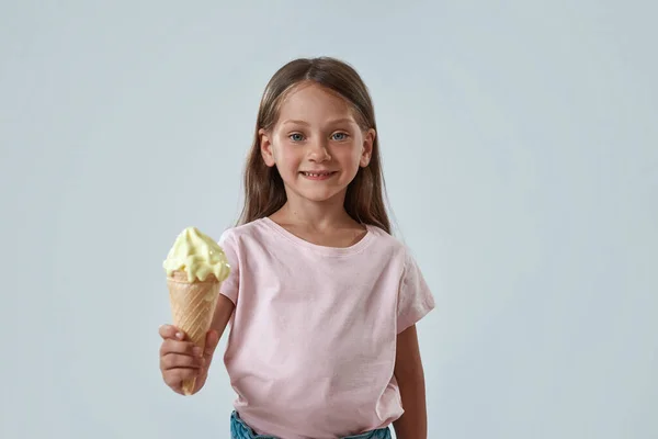 Smiling little girl showing sweet ice cream cone — Stock Photo, Image