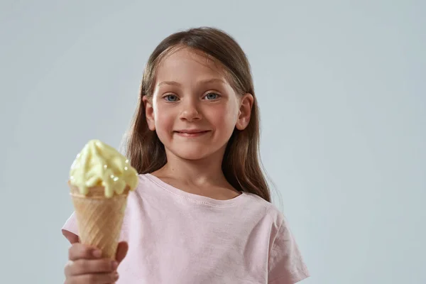 Low angle view of little girl show ice cream cone — Stock Photo, Image