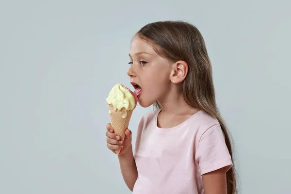Little girl licking sweet delicious ice cream cone — Stock Photo, Image