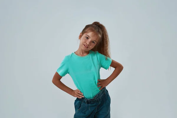 Serious girl with hands on hips looking at camera — Stock Photo, Image