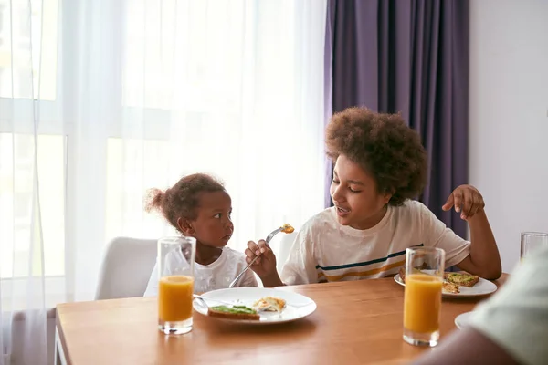 Oğlan, kız kardeşine kendini yumurtalarla nasıl beslediğini gösteriyor. — Stok fotoğraf