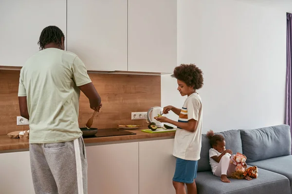 Μαύρη οικογένεια του μπαμπά και του γιου μαγειρεύουν πρωινό στο σπίτι — Φωτογραφία Αρχείου