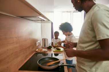 Baba ekmeğe kivi tozu süren oğluna bakıyor.