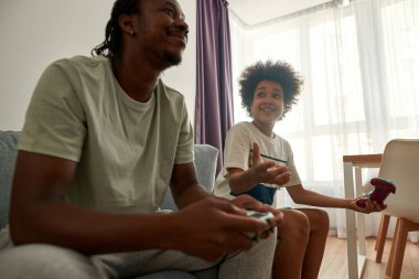 Tatminsiz çocuk video oyunu oynarken babana bak.