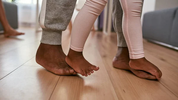Barefoot vader en dochter gaan op de vloer in huis — Stockfoto