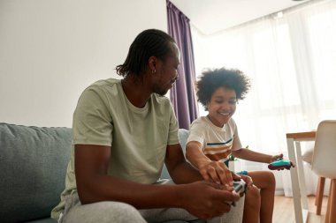 Oyun oynarken babanın kumandasındaki düğmeye bas.