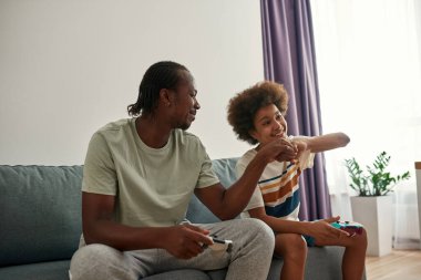 Siyah baba ve oğul video oyunu oynarken yumruk tokuşturuyorlar