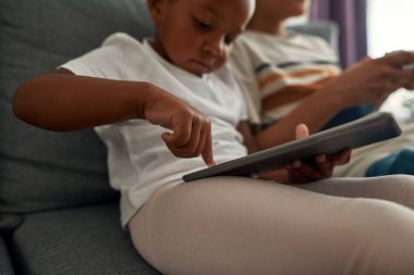 Kız, erkek kardeşiyle birlikte dijital tablete basıyor