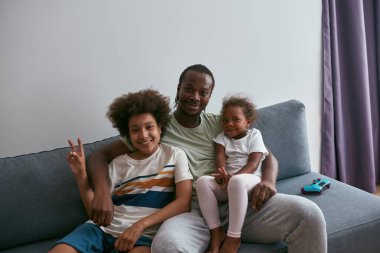 Siyahi aile dinleniyor ve zafer işareti yapıyor.