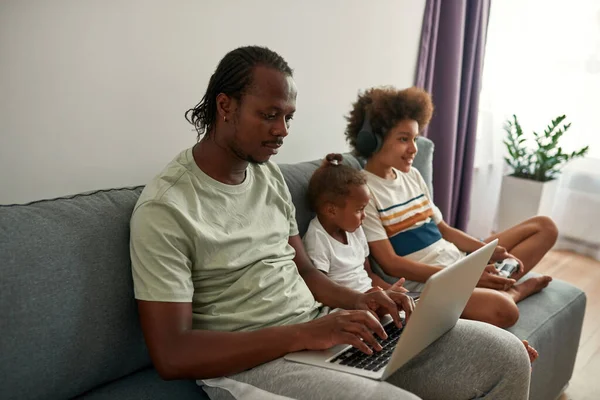 Fekete család digitális eszközök kanapén otthon — Stock Fotó