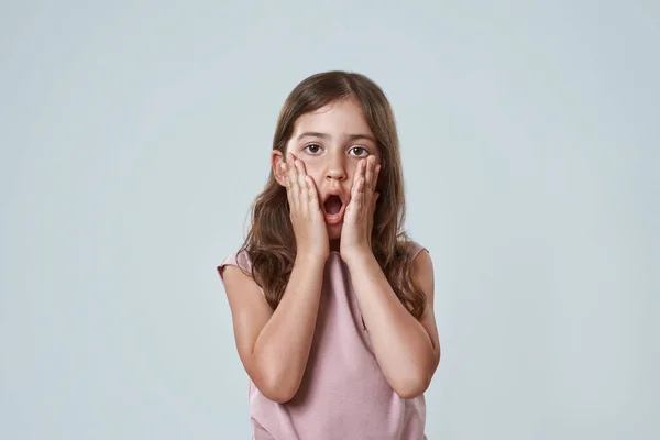 Передній вигляд шокованої маленької дівчинки торкнутися її обличчя — стокове фото