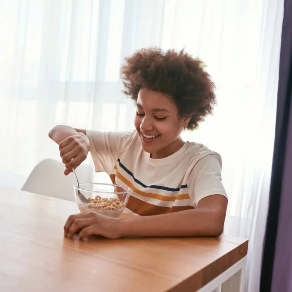 Χαμογελώντας μαύρο αγόρι τρώνε δημητριακά με κουτάλι από το μπολ — Φωτογραφία Αρχείου
