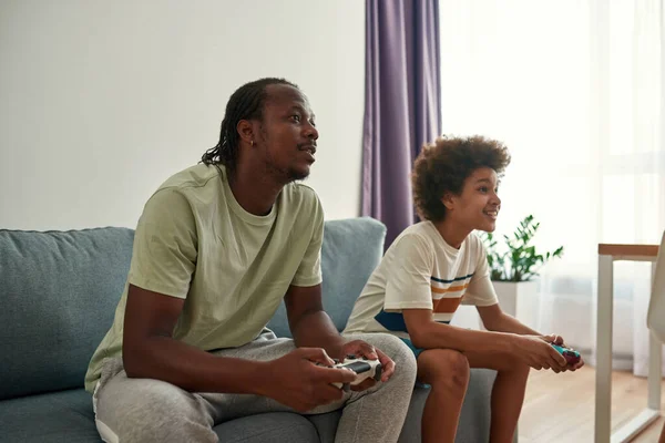 Negro padre e hijo jugar videojuego en joysticks —  Fotos de Stock