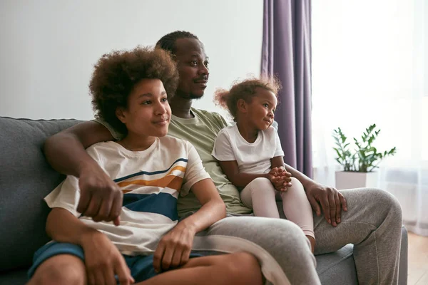 Μαύρη οικογένεια βλέποντας τηλεόραση ή ταινία στον καναπέ στο σπίτι — Φωτογραφία Αρχείου