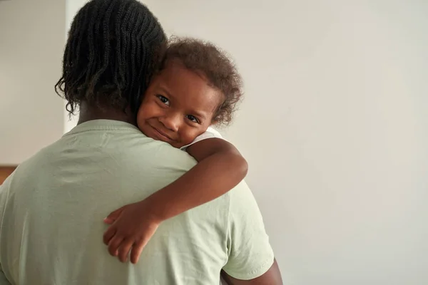 Zadní pohled na černošky otec držet a objímat dceru — Stock fotografie