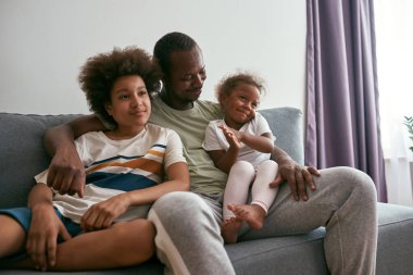 Baba TV izlerken kızına ve oğluna sarılıyor.