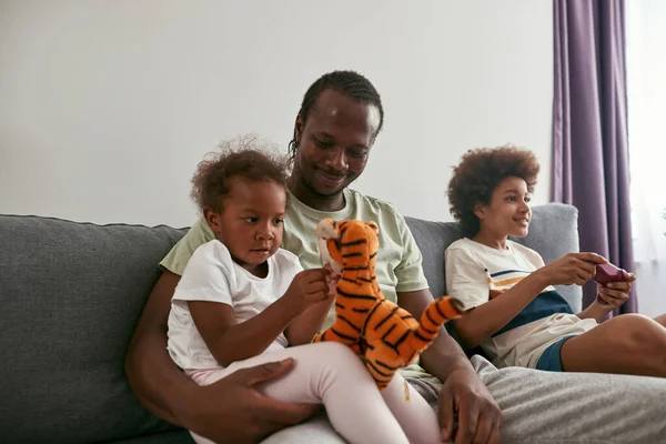 Famiglia nera trascorrere del tempo insieme sul divano a casa — Foto Stock