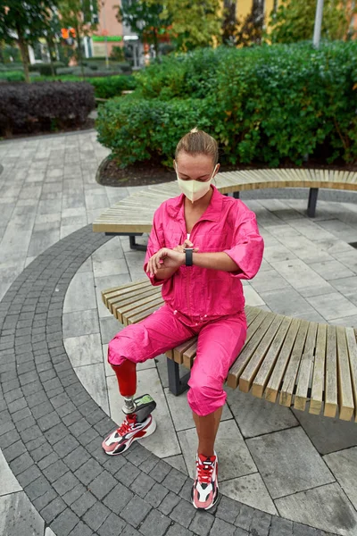 Girl with artificial leg watch on fitness tracker