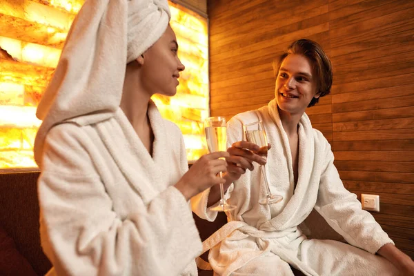 Smiling couple toast and drink champagne in spa — ストック写真