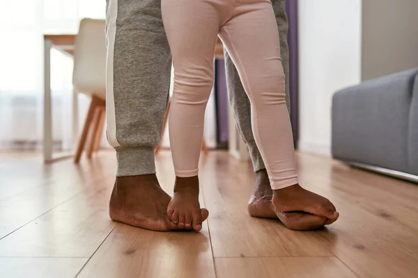 Gedeeltelijk van blootsvoets vader en dochter gaan op de vloer — Stockfoto