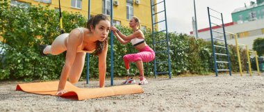 Atletik kız engelli kız arkadaşıyla egzersiz yapıyor.