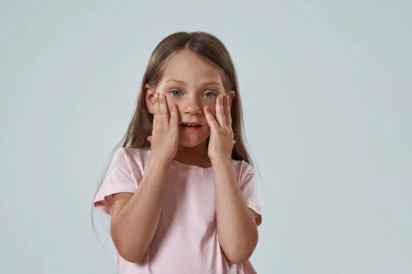 Cropped of surprised little girl touching her face — Stock Photo, Image