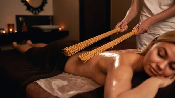 Parcial de masajista hacer masaje de mujer con palos — Foto de Stock