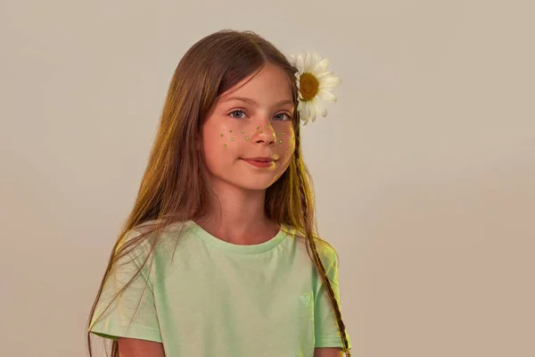 Vážná holčička s heřmánkovým květem ve vlasech — Stock fotografie