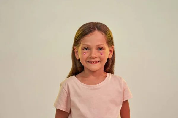 Rózsaszín szívű kislány strasszos arccal — Stock Fotó