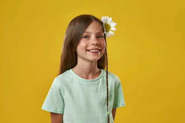 Niña sonriente con flor de manzanilla en el pelo —  Fotos de Stock