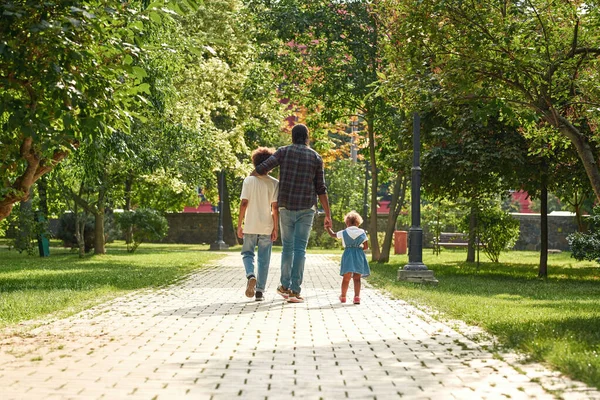 Padre con niños caminan por el camino del pavimento en el parque — Foto de Stock